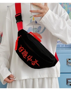 Detail der roten chinesischen Stickerei auf schwarzer Canvas-Umhängetasche mit Nylonband