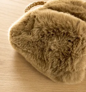Macro side view showing the dense plush texture and woven leather handle of the bag