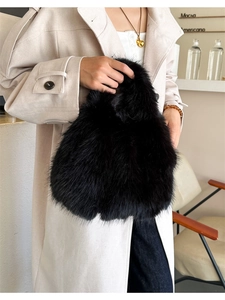 Détail d'un sac à main en fausse fourrure noire associé à un trench-coat beige élégant