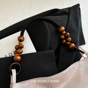 Détail d'une bandoulière en corde tressée avec perles en bois sur sac en jacquard