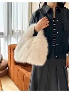 Détail de la texture douce en fausse fourrure d'un sac à main en peluche blanc crème