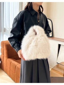 Détail d'un sac à main en fausse fourrure blanche porté par un mannequin en studio