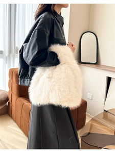 Gros plan du sac à main en fausse fourrure blanche assorti à une veste en cuir noir