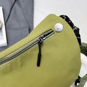Detalle de cremallera de nylon negra y tejido ripstop verde texturizado en bolso bandolera