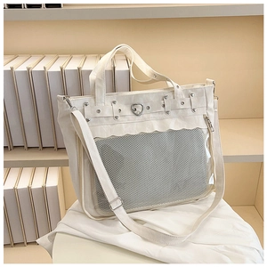 Détail du sac fourre-tout blanc avec mesh transparent, boucle cœur et rivets en métal