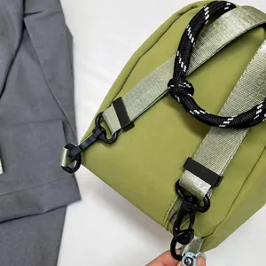 Detalle del gancho desmontable y la textura de nailon tejido del bolso verde