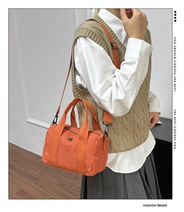 Model wearing orange canvas boston bag showing size and crossbody style for casual look