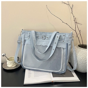 Détail du sac ita bleu clair avec poche en filet transparent et boucle en métal cœur