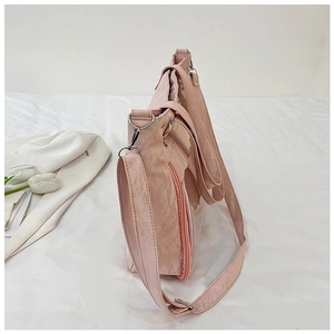 Détail du sac à bandoulière rose clair avec texture plissée et anneau en D argenté