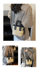 Detalle del mini bolso tote con costuras en contraste, remaches dorados y asa de cuero