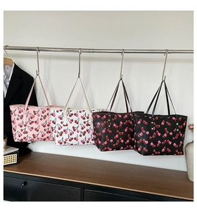 Detalle de bolsos tote grandes estampados en colores rosa, blanco, marrón y negro