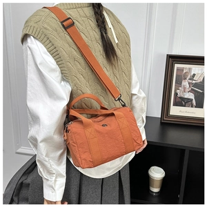 Detail of caramel nylon crossbody bag with adjustable strap and silver metal accent