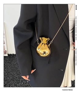 Détail de la pochette en acrylique doré miroir avec une fine chaîne métallique
