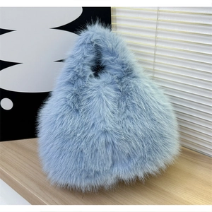 Détail d'un sac à main en fausse fourrure bleu clair sur étagère avec décor d'art