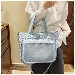 Détail du sac cabas perle bleu clair avec poche filet et boucle cœur en main