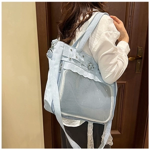 Détail du sac bandoulière bleu clair avec volants, breloque cœur et fenêtre en filet