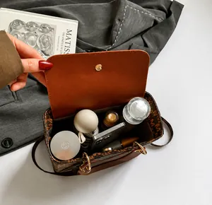 Internal view of brown monogram handbag showing its large capacity for daily essentials