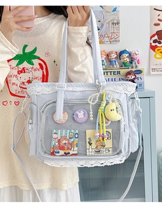 Detail der hellblauen Ita-Tasche mit Spitzenbesatz, Klarsichtfenster und Perlenanhänger