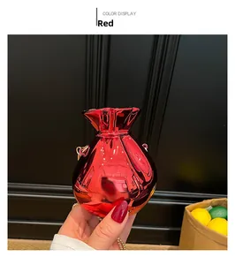 Dettaglio borsa da sera rossa metallizzata a forma di sacchetto con catena dorata