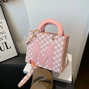 Pink leather mini tote bag with letter M monogram pattern and round top handle