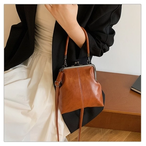 Détail d'un sac à main rétro en cuir marron avec fermoir métallique classique et surpiqûres