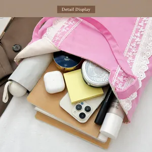 Detalle del bolso tote de lona rosa que muestra el interior espacioso con cosméticos
