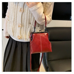 Détail d'un sac docteur vintage rouge avec fermoir à baiser argenté et texture cirée