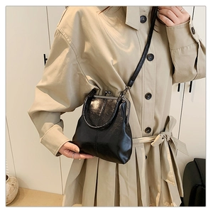 Détail du sac à main vintage noir à fermoir bisou en cuir PU brillant avec poignée courte