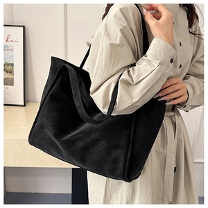 Minimalist black tote bag shown on model with shoulder strap for daily casual style