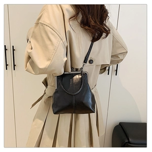 Détail d'un sac shell noir vintage avec fermoir métallique et bandoulière en cuir