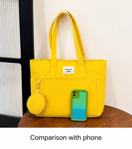 Detail of yellow canvas tote bag with front pocket and a small round hanging coin purse