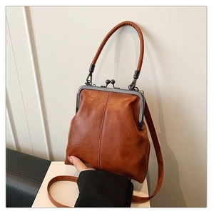 Détail d'un sac vintage en cuir PU marron avec fermoir métallique et coutures verticales