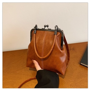 Détail du sac rétro marron caramel avec doubles coutures blanches et fermoir en métal