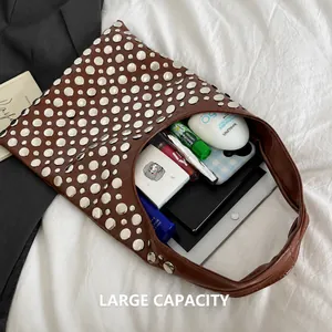 Vue de dessus du sac clouté marron montrant sa grande capacité pour les essentiels quotidiens