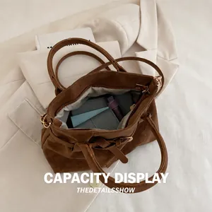 Interior storage capacity of the brown suede tote bag with phone and wallet