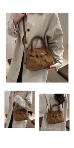 Detailed view of suede texture and gold buckle hardware on a brown tote bag