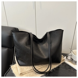 Retro black textured tote bag with long shoulder straps on a cozy minimalist background