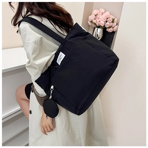 Detail of black nylon tote bag with detachable coin purse and branded woven label