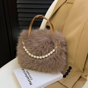 Dettaglio della borsa di peluche marrone con catena di perle bianche e fibbia dorata