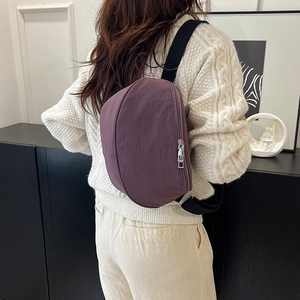 Mannequin portant un sac bandoulière croissant en nylon violet sur un pull blanc