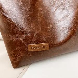 Macro detail of dark brown leather texture with embossed fashion label on shoulder bag