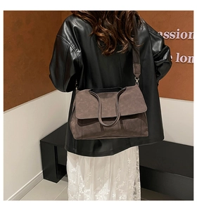 Detailed view of a dark brown crossbody tote bag with a wide fabric shoulder strap
