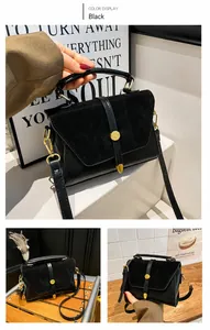 Close-up of black crossbody bag featuring smooth and matte leather with gold buckle