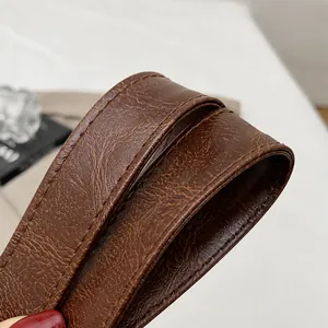 Close-up of durable brown leather shoulder strap with high-density precision stitching