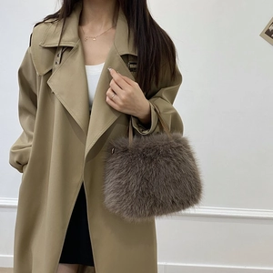 Dettaglio borsa in finta pelliccia marrone scuro con catena su cappotto kaki