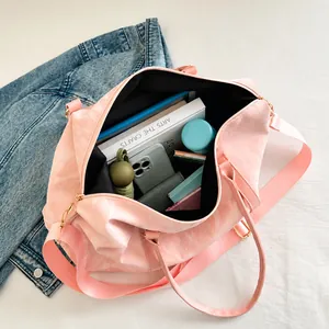 Pink large capacity travel bag interior showing organized books and daily essentials
