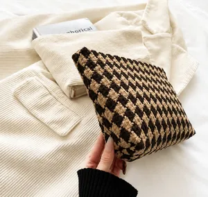 Close-up of brown houndstooth knit long wallet clutch with premium textured fabric finish