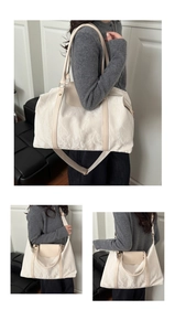 Détail d'un sac de voyage beige avec texture plissée et poignées en similicuir kaki