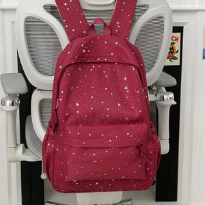 Vue détaillée du sac à dos bordeaux à motifs d'étoiles avec poches sur une chaise