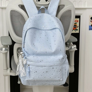 Détail du sac à dos bleu clair étoilé avec pendentif délicat en dentelle et perles